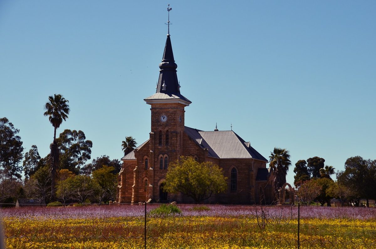 The Dutch Reformed church at Nieuwoudtville with spring flowers in front of it