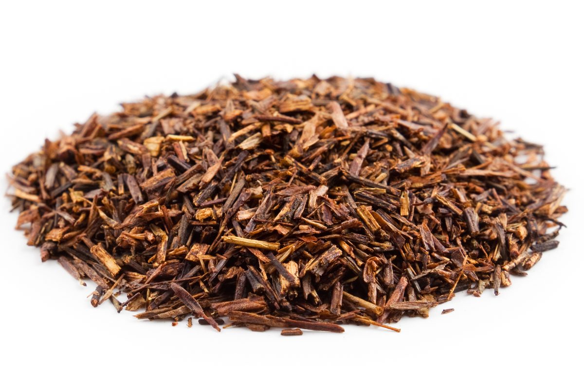 A heap of cut and dried rooibos leaf and stem, reddish brown
