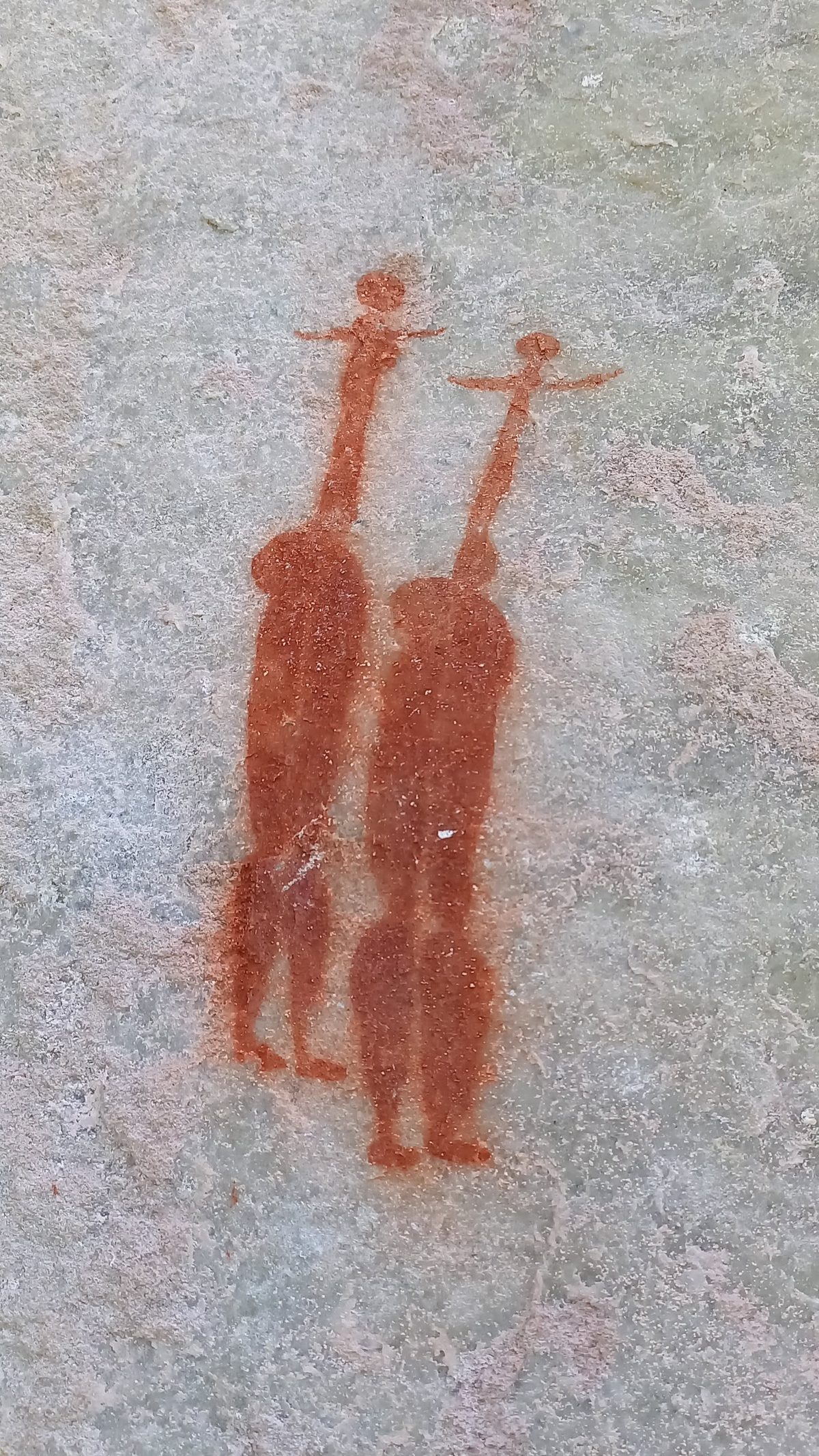 Two San rock-art figures painted in red ochre on pale sandstone